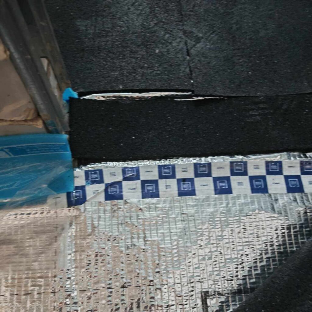 Aluminum barrier under MGE acoustic mat.